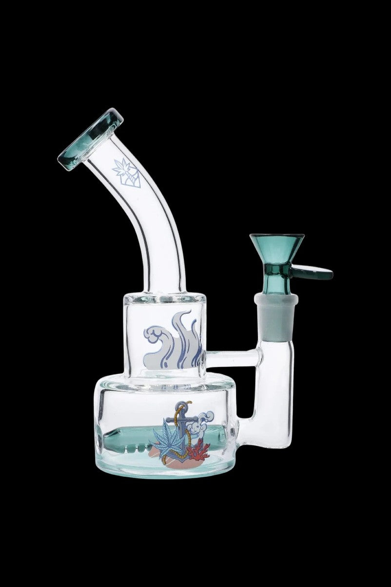 Angled front view of the Cabana Cannabis Co. Ahoy Dab Rig - Teal showing its curved neck, teal bowl and nautical decal on clear glass