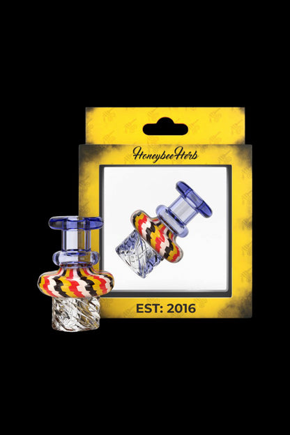 A packaged cannabis concentrate carb cap with colorful glass accents, labeled “Honeybee Herbs EST: 2016.”