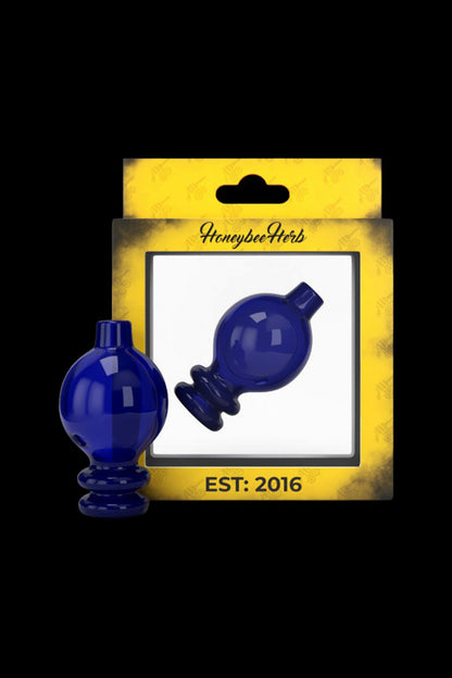 Blue glass dab caps in packaging labeled “Honeybee Herb Est: 2016”.