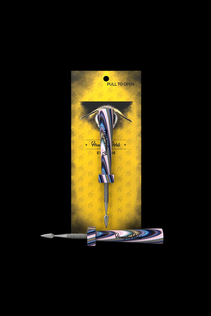 A gold and black box displaying a sleek, iridescent cannabis dab tool with a bee-themed design.