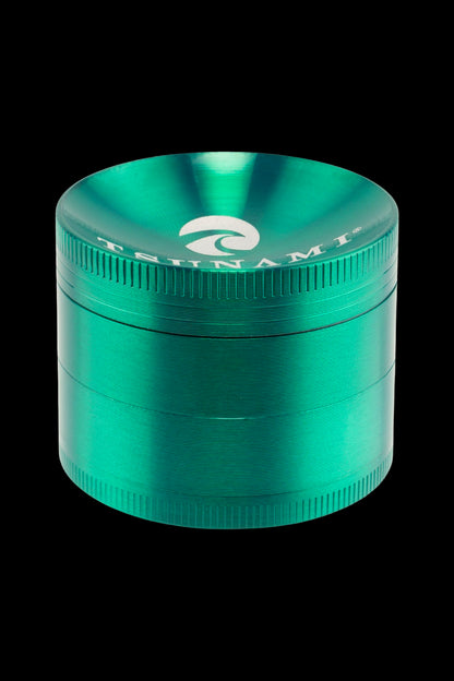 Teal metal cannabis grinder with a wave-like logo.