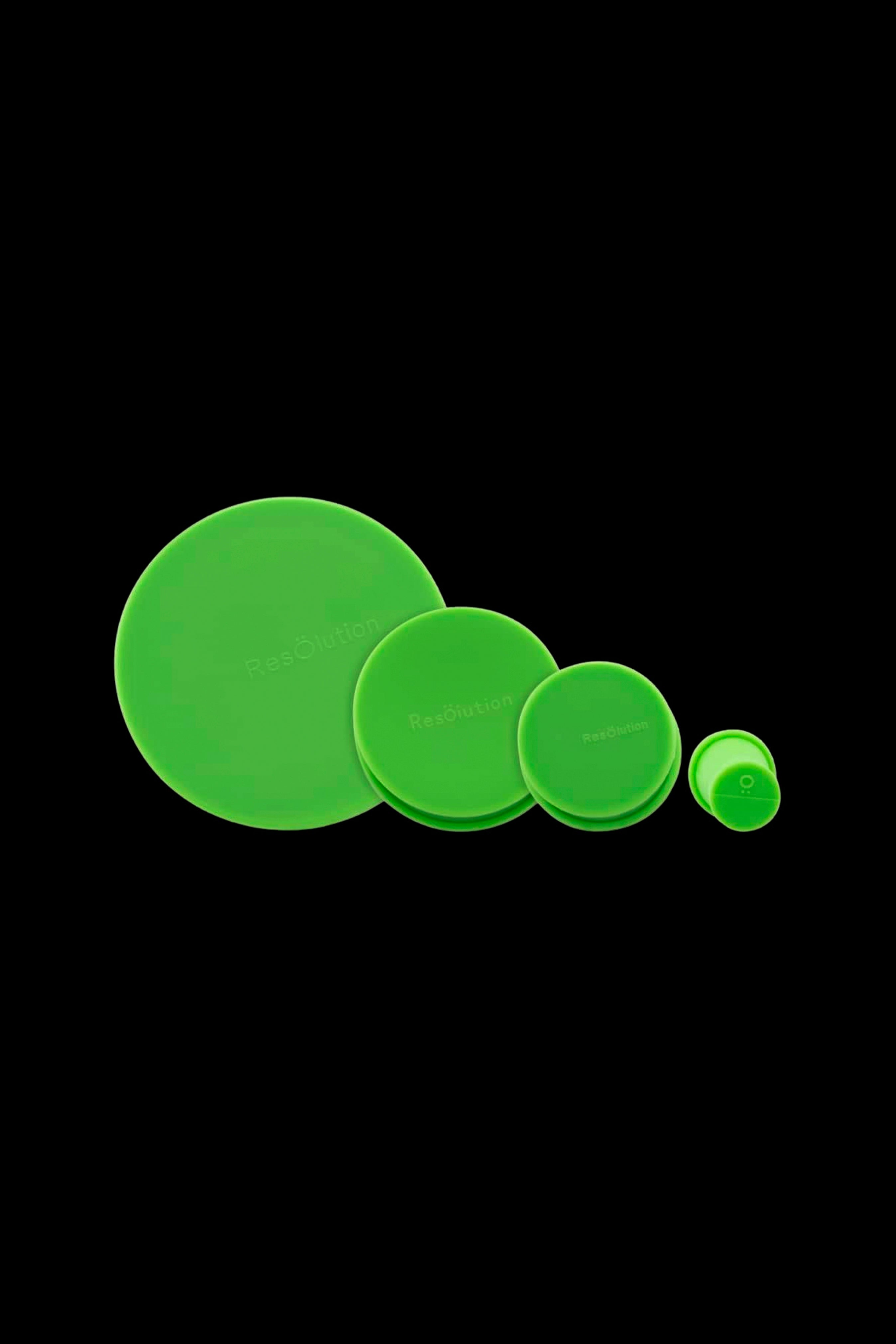 Diagonal row of bright green Ooze Resolution Caps Cleaning Caps in four sizes against a black background.