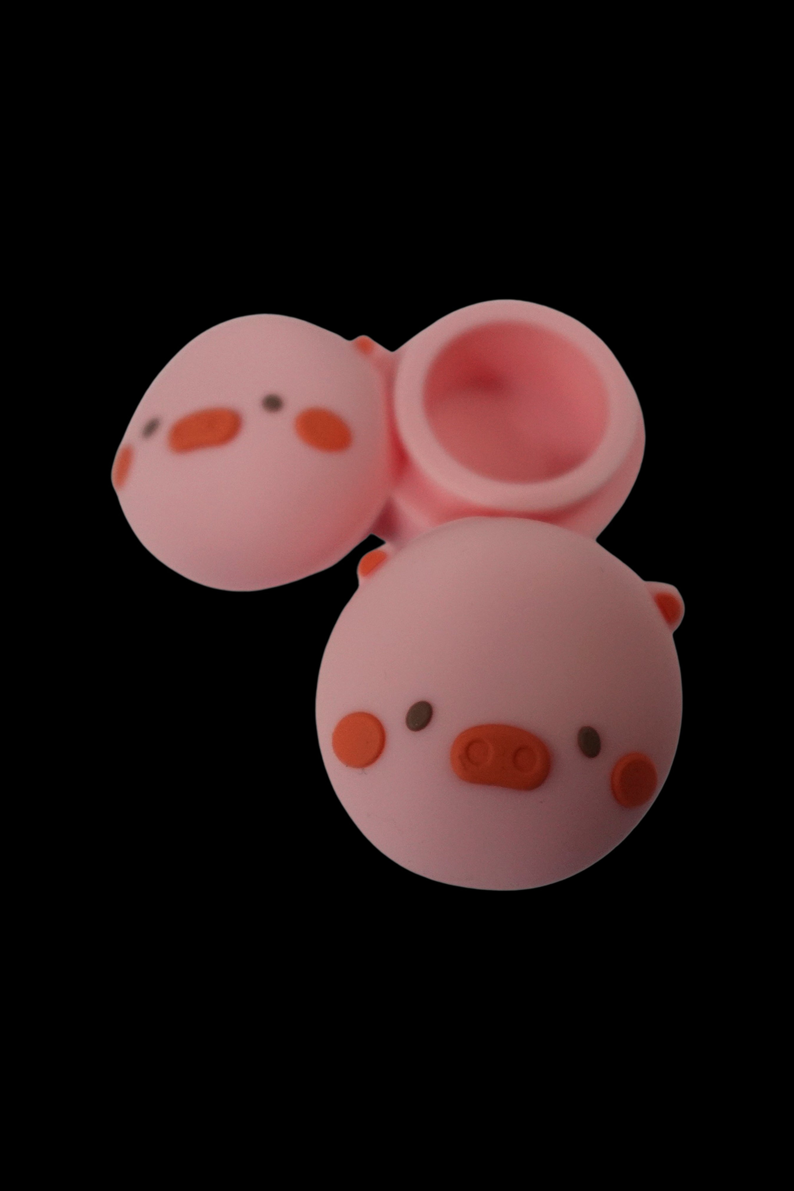 Pink silicone container with two connected spheres, open to reveal interior.