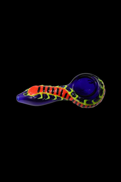 Glass pipe with a snake-like design in vibrant red, yellow, and purple against a black background.