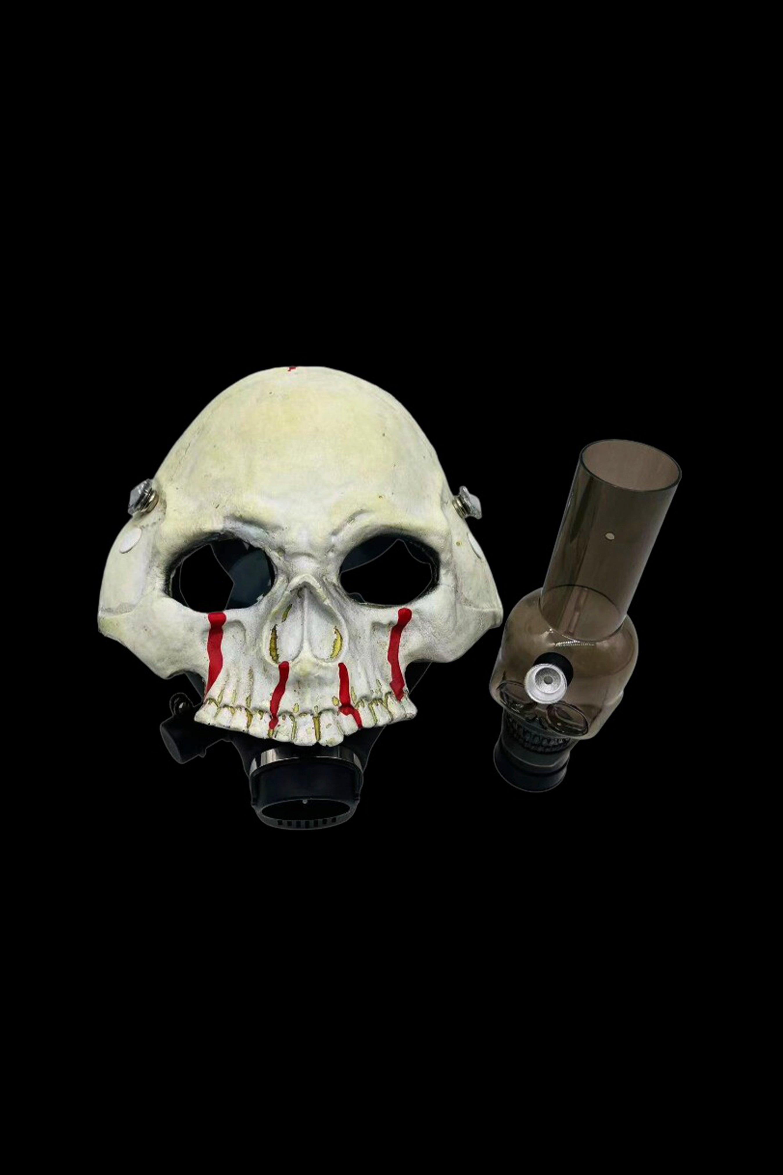 Skull-shaped glass pipe with red accents against a black background.