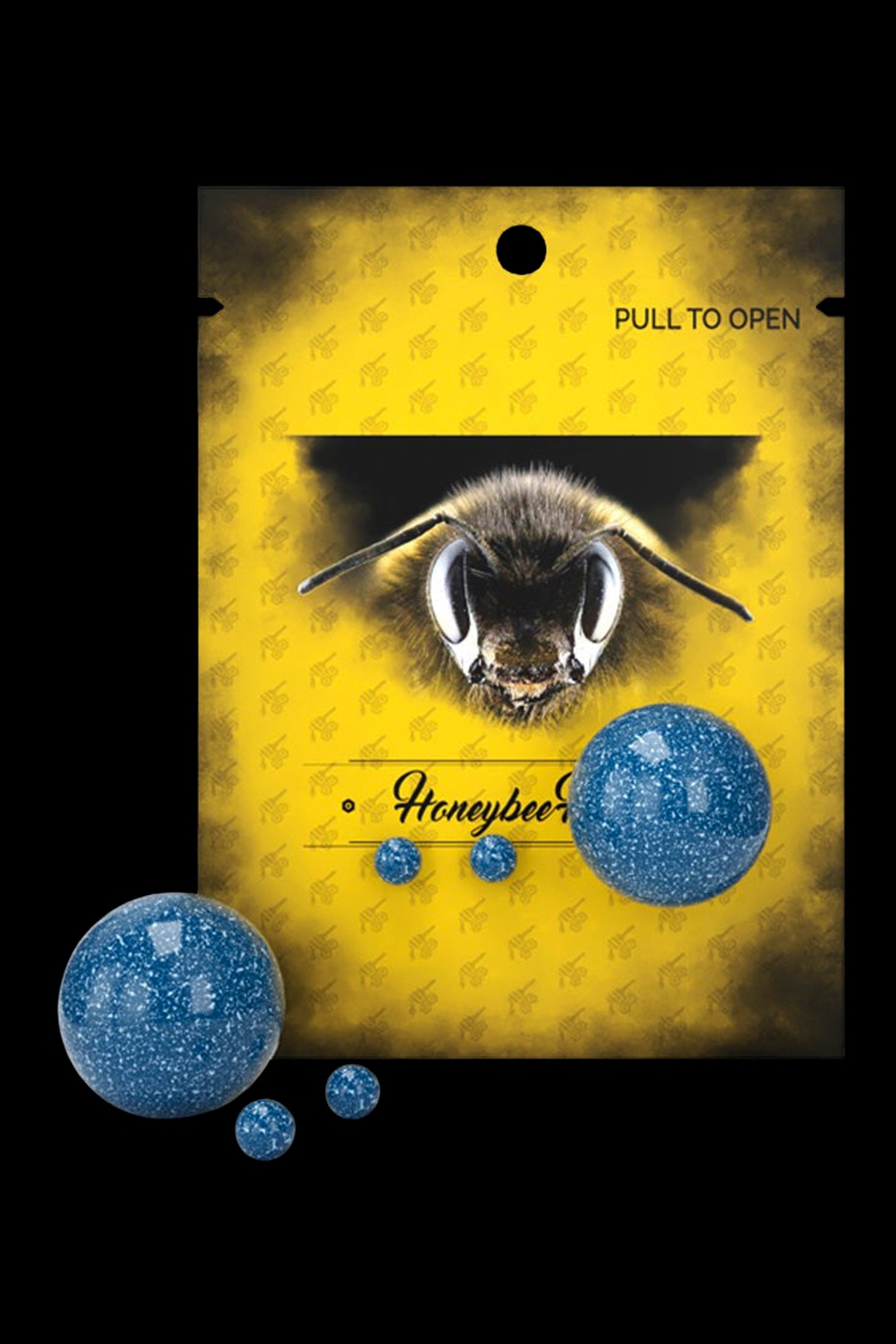 Yellow cannabis packaging with a close-up of a bee and blue glittery spheres.