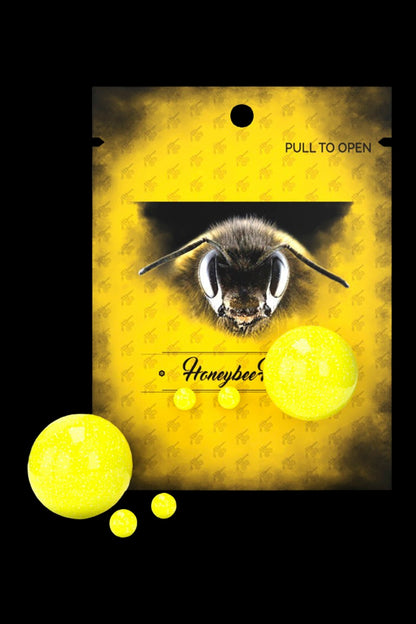 Yellow packaging for “Honeybee” cannabis accessory, featuring a close-up of a bee's face and scattered golden orbs."