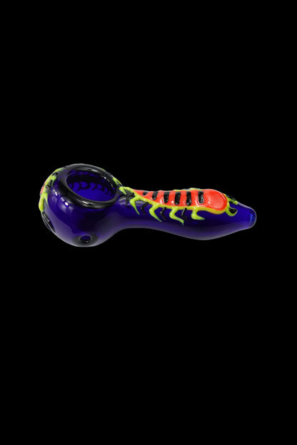 Glass pipe with a vibrant spider design, isolated on a black background.
