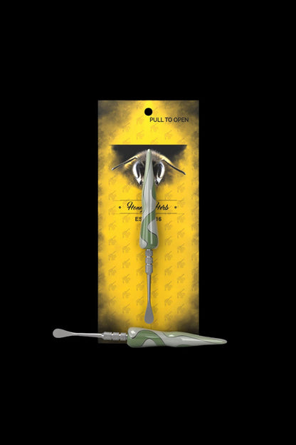 A packaged cannabis dab tool with a bee-themed design.