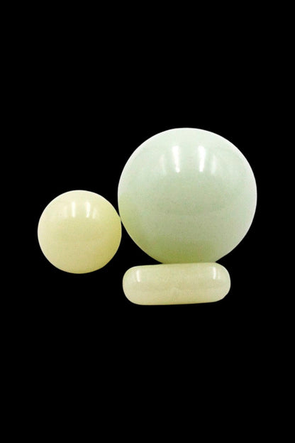 Jade-colored cannabis capsules and pills isolated on a black background.