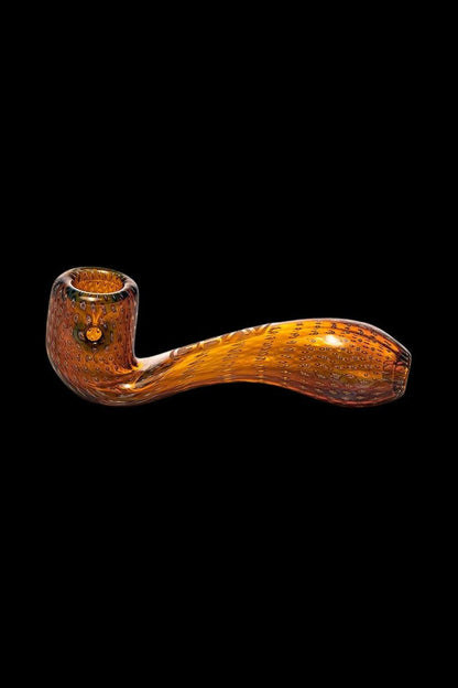 Ornate orange glass pipe against a black background.