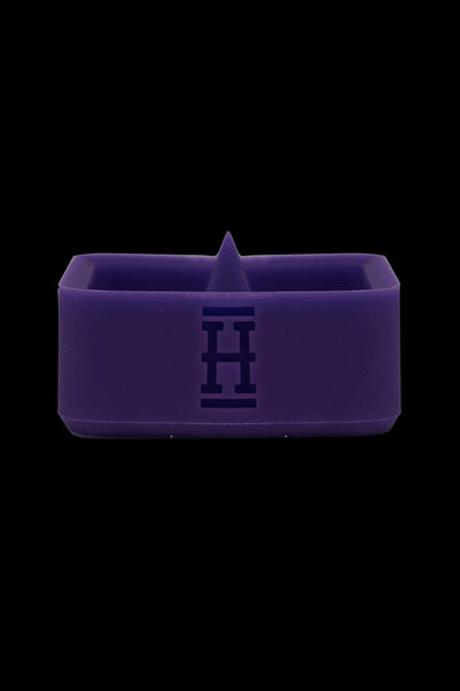 Purple silicone concentrate container with embossed logo.