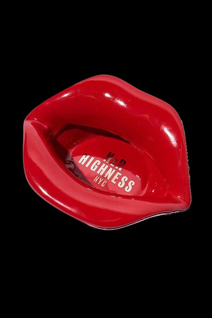 Red lips-shaped cannabis pipe with “Highness NYC” branding against a black background.
