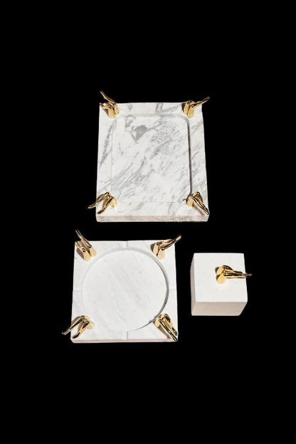 Marble cannabis accessory set with gold accents, including a tray, ashtray, and storage box on a black background.