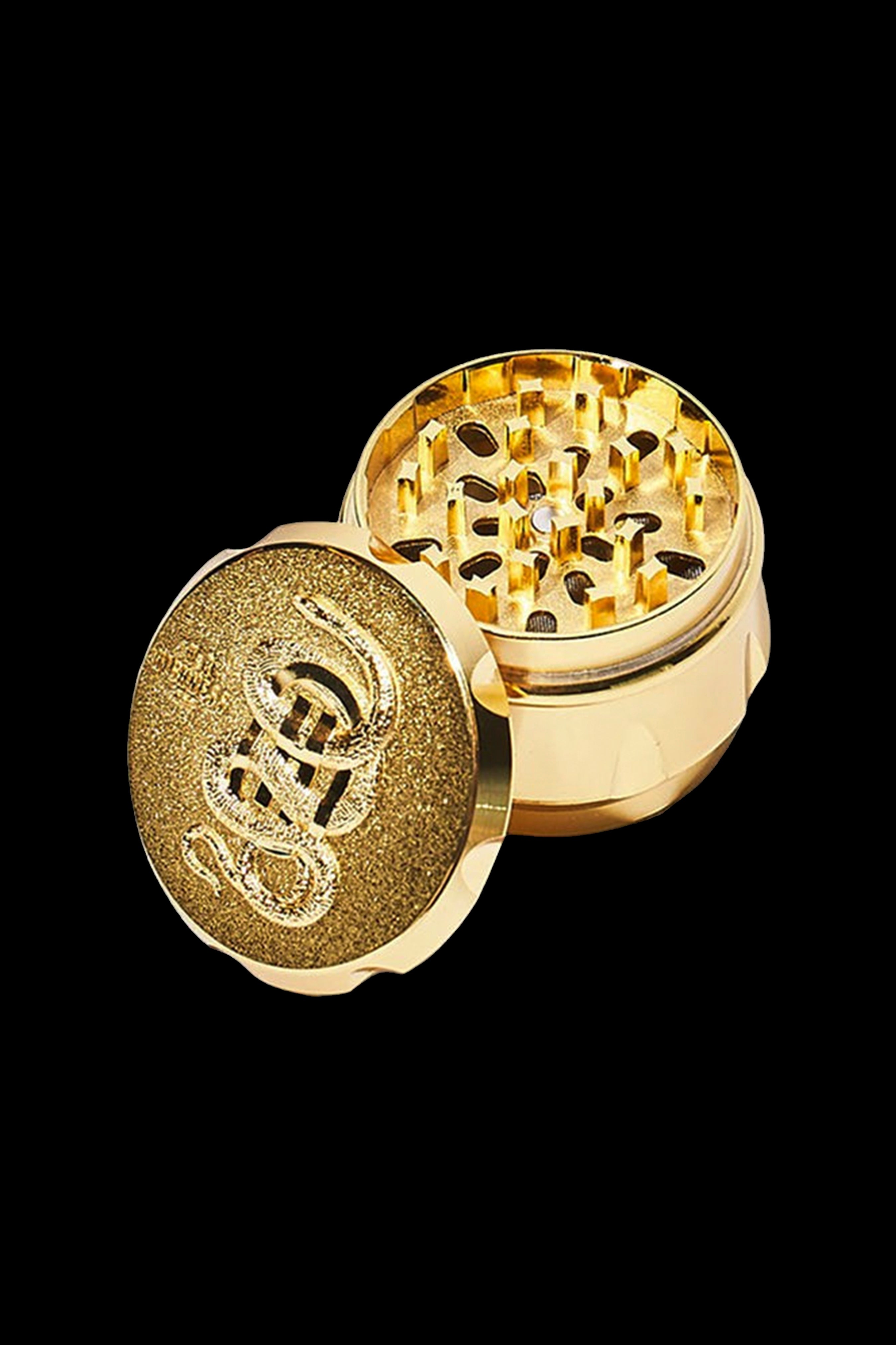 Gold cannabis grinder, open to reveal internal grinding mechanism.