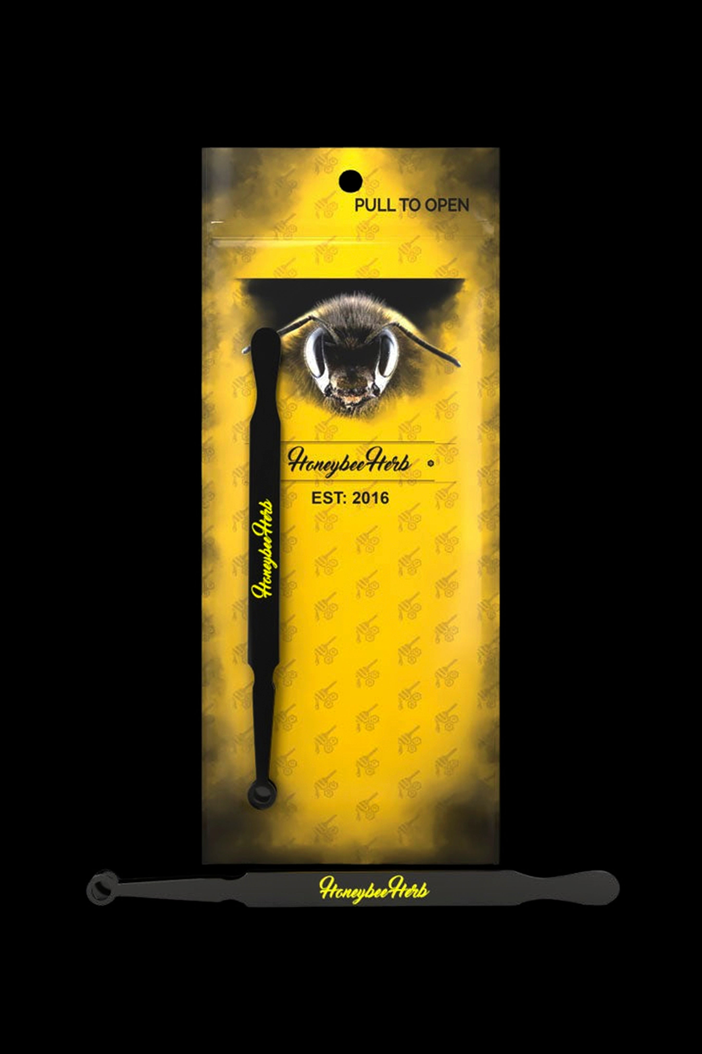 Yellow mylar bag for Honeybee Herbs cannabis accessories, featuring a bee illustration and two black dab tools inside.