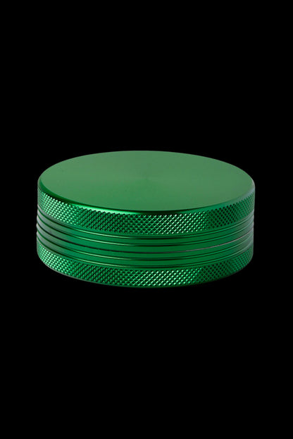 Green four-piece metal grinder for cannabis.