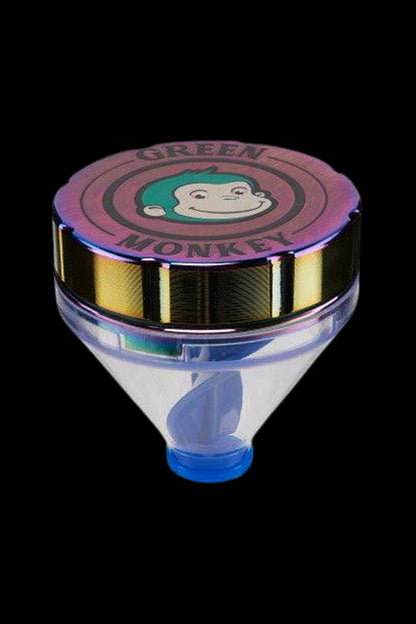 Close-up front view of the Green Monkey Patas Grinder lid showing a smiling green-haired monkey logo on a metallic iridescent top.