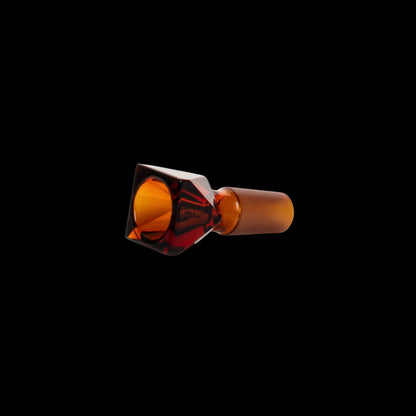 Amber glass cannabis bowl with faceted design on black background.