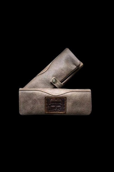 Leather cannabis case open and closed, displaying a branded label.