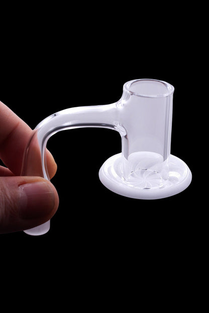 Clear glass dab rig insert held by a hand against a black background.