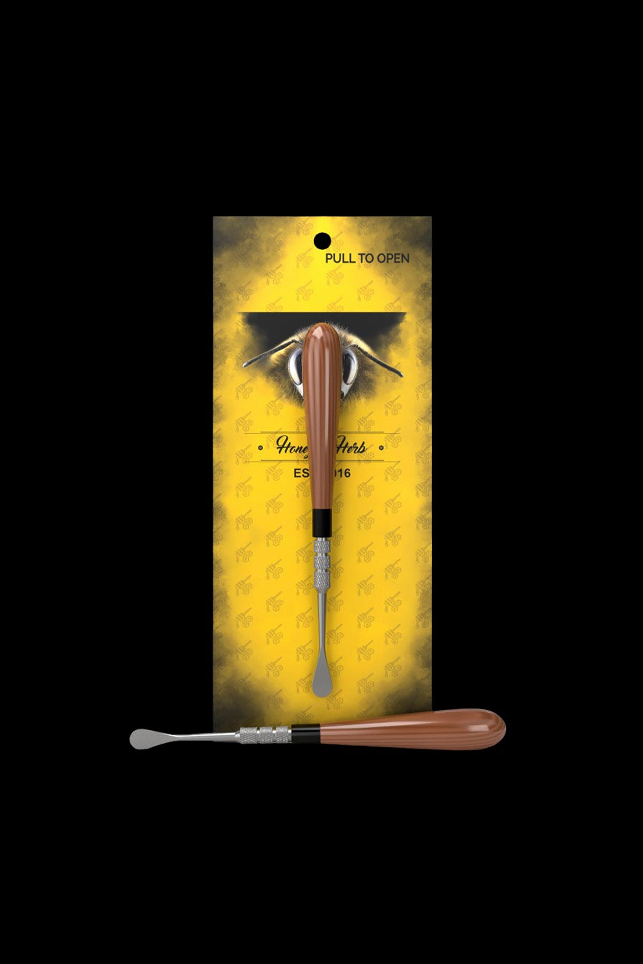 Top-down view of the Honeybee Herb Classic Dab Tool with an orange glossy handle mounted on yellow branded backing.