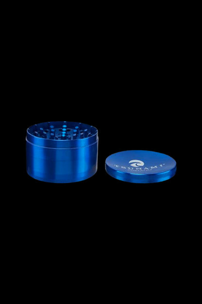 Blue metal cannabis grinder with open lid beside it.