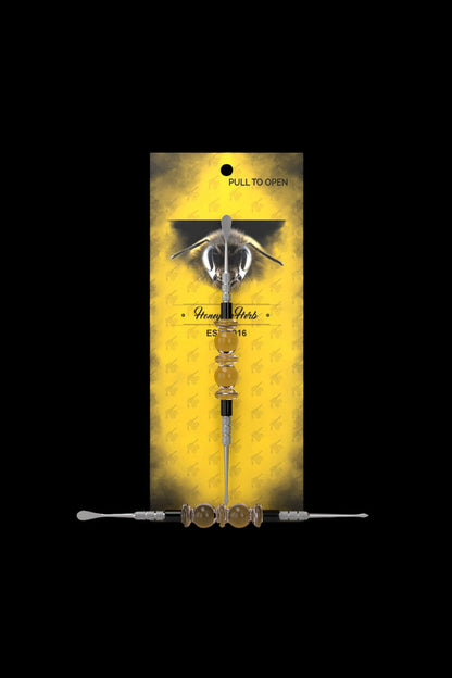 Yellow packaging for “Honey Herbs” cannabis accessory displays a glass oil burner pipe with a honeybee illustration.