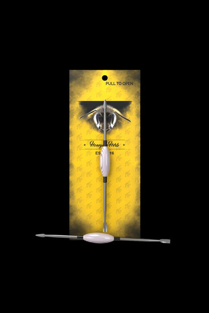 A vertical, rectangular cannabis packaging box with a bee illustration and the brand name ""Honeye Herbs"" displaying a metallic dab tool inside."