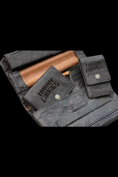 Black textured cannabis accessory case with “Tommy Chong” branding, open to reveal wooden smoking tools and compartments.
