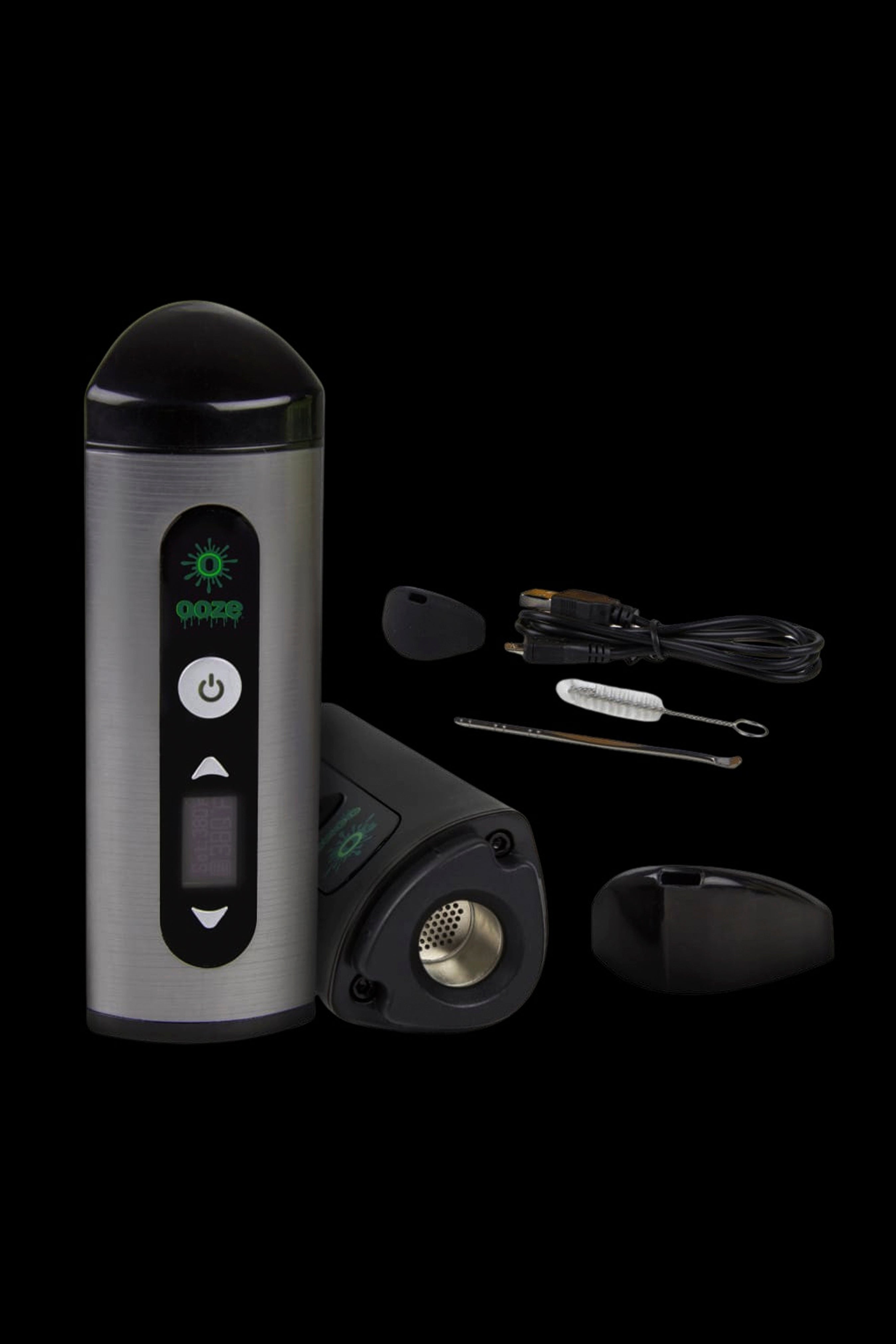 Silver cannabis vaporizer pen with included mouthpiece, cleaning tools, and charging base displayed on a black background.