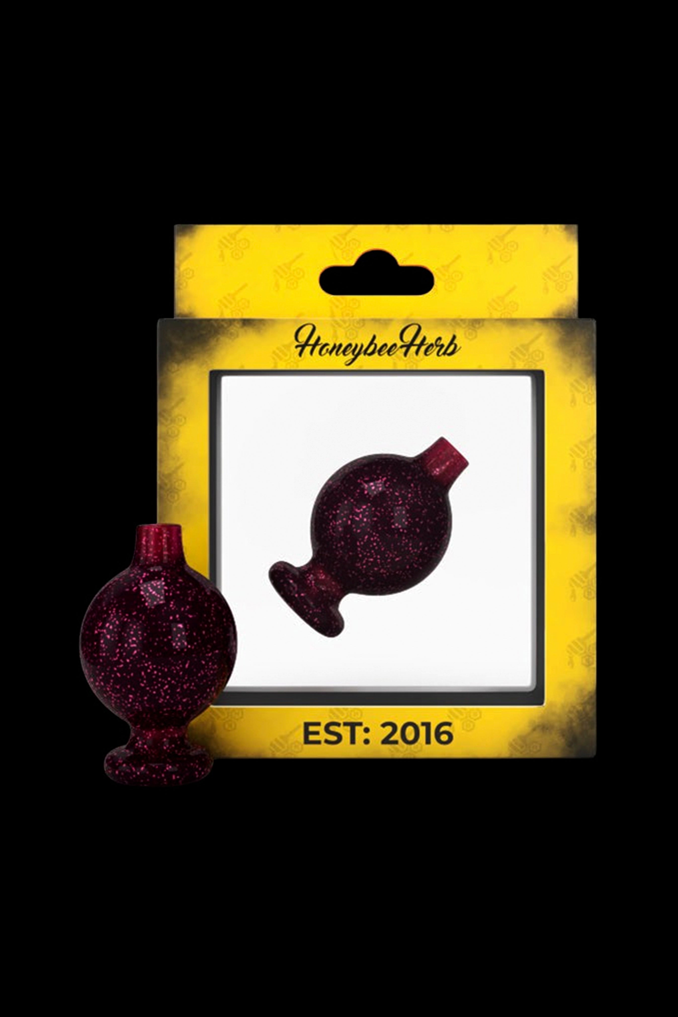Red glitter oil burner dab rig on packaging labeled “Honeybee Herbs Est. 2016.”