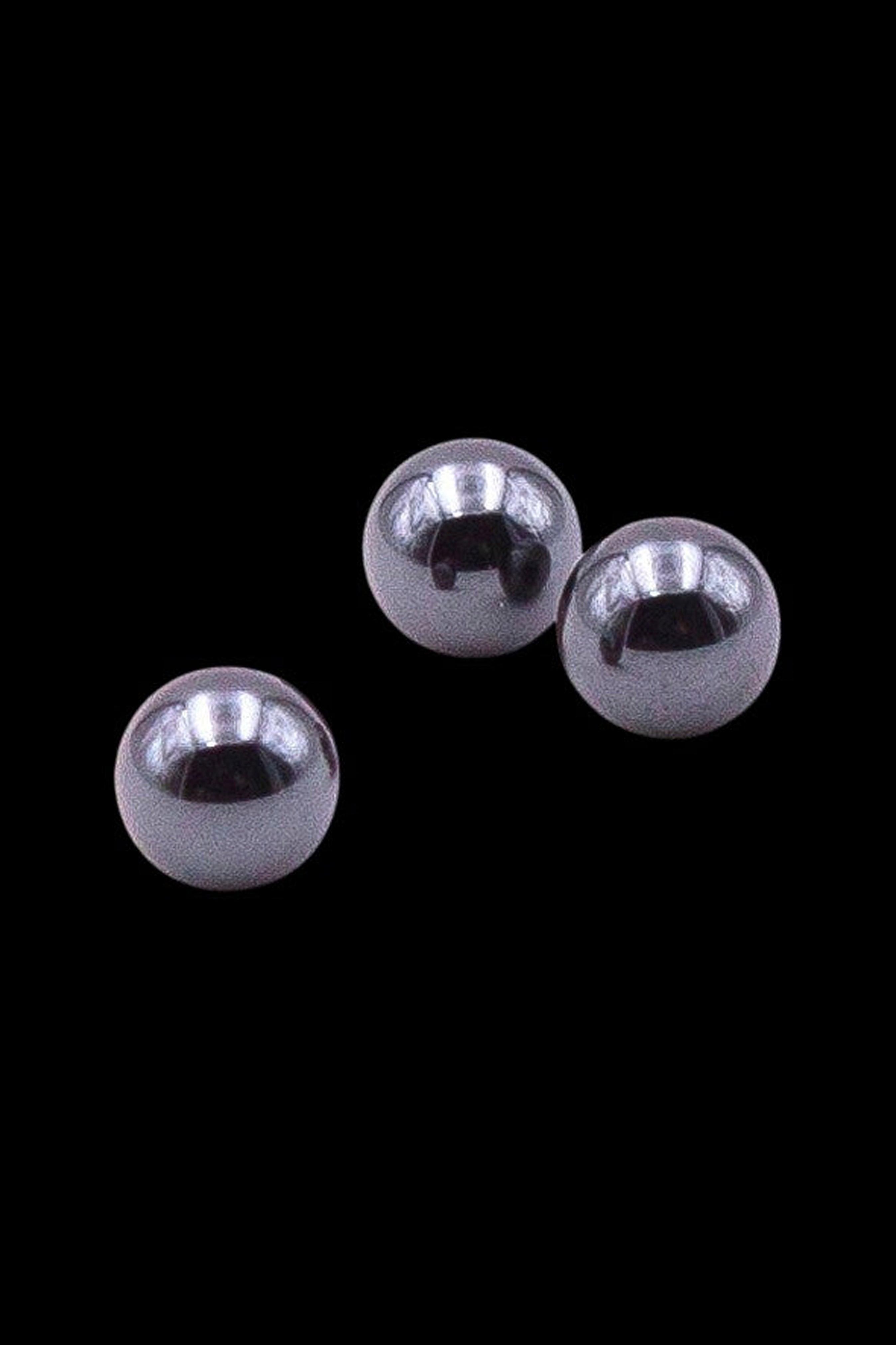 Silver glass marbles against a black background, likely for use in a water pipe or dab rig.