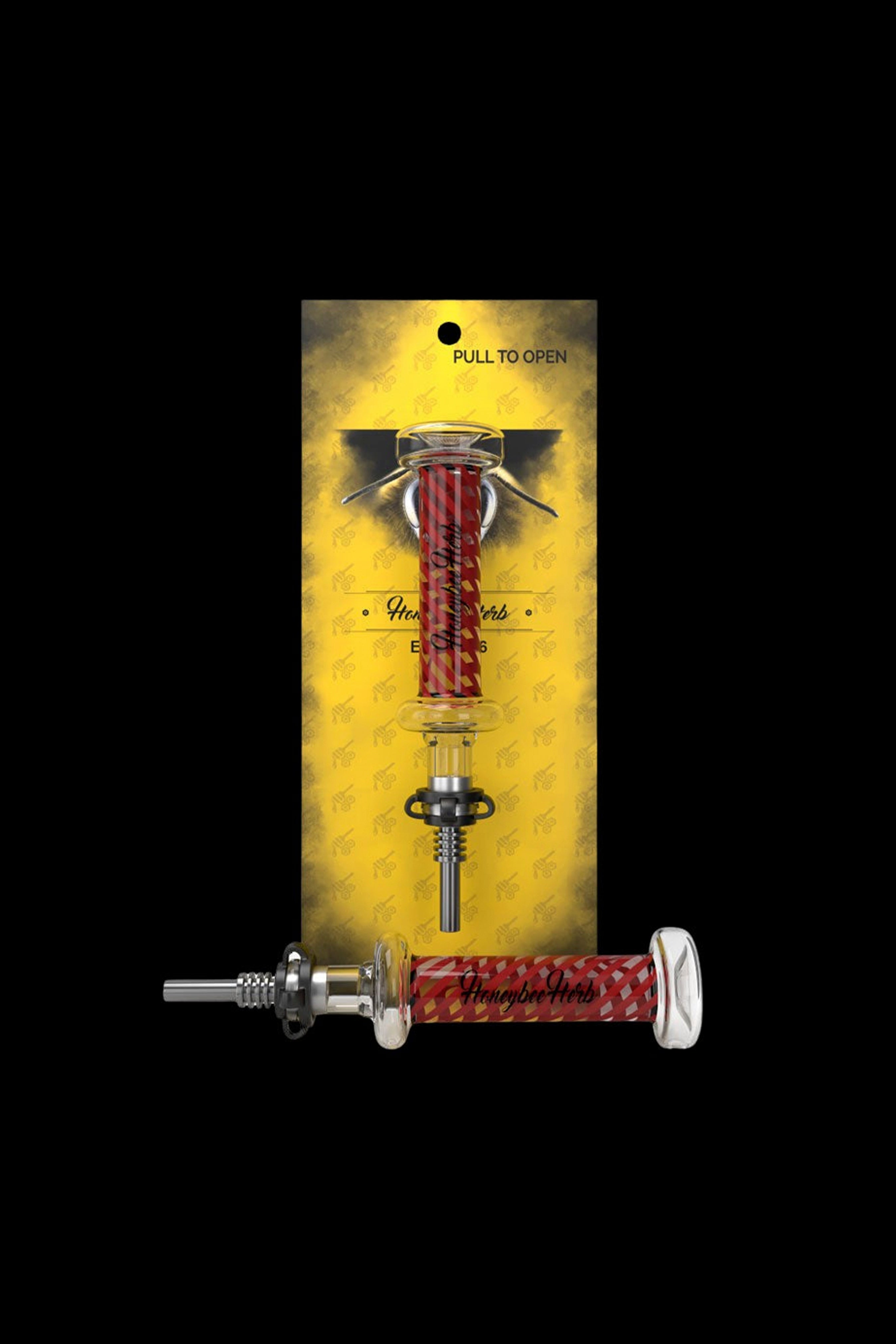 A packaged cannabis dab straw with a red and white patterned body, displayed against a gold patterned background.