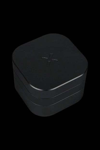 Black cannabis storage container with a stylized cross symbol.