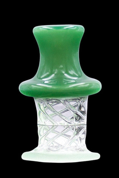 Close-up, straight-on view of The Stash Shack UFO Spinning Carb Cap showing a glossy blue-green top and a clear glass stem with twisted internal filaments against a black background