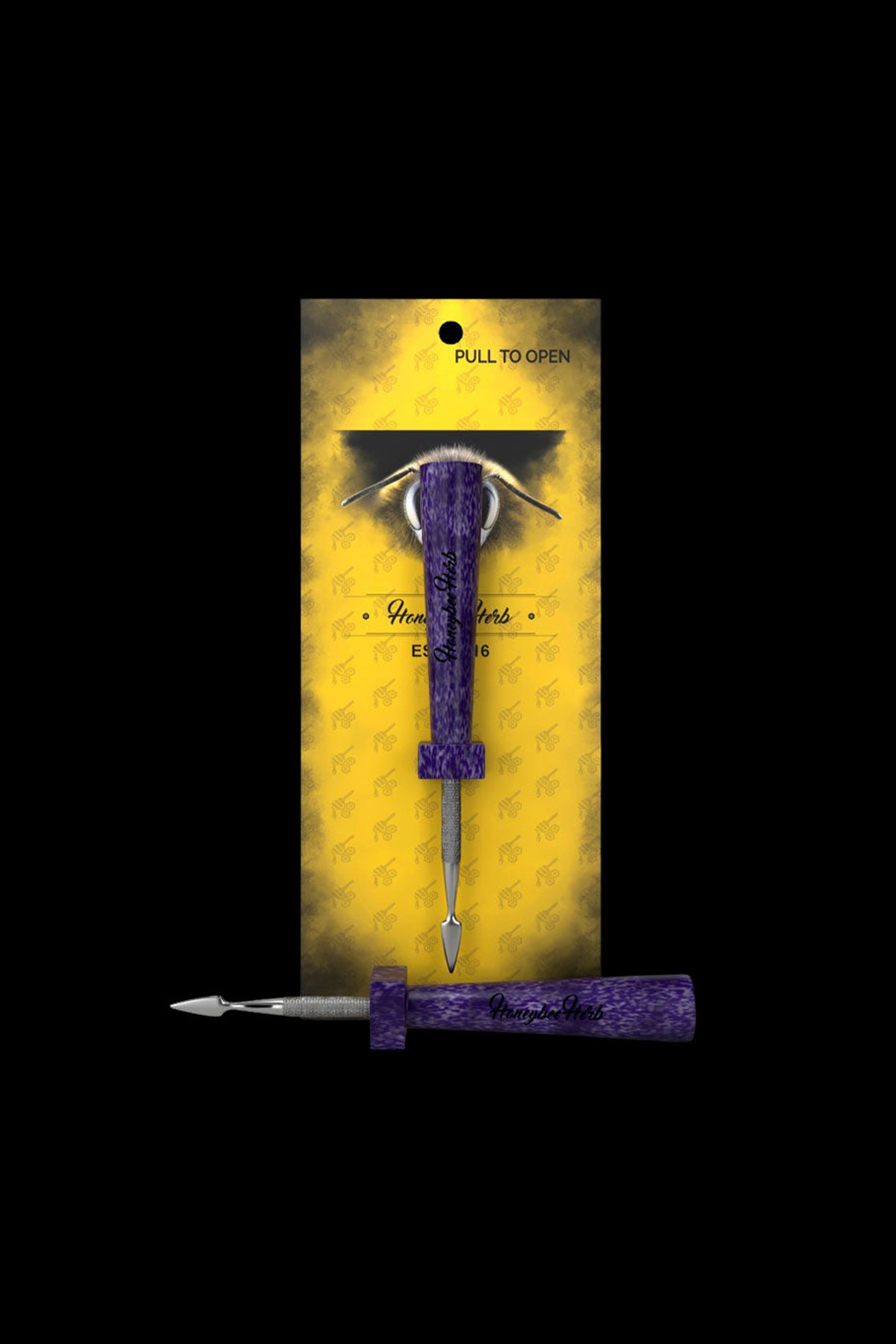 Purple cannabis dab tool with an eye-shaped design, packaged in a patterned gold sleeve.