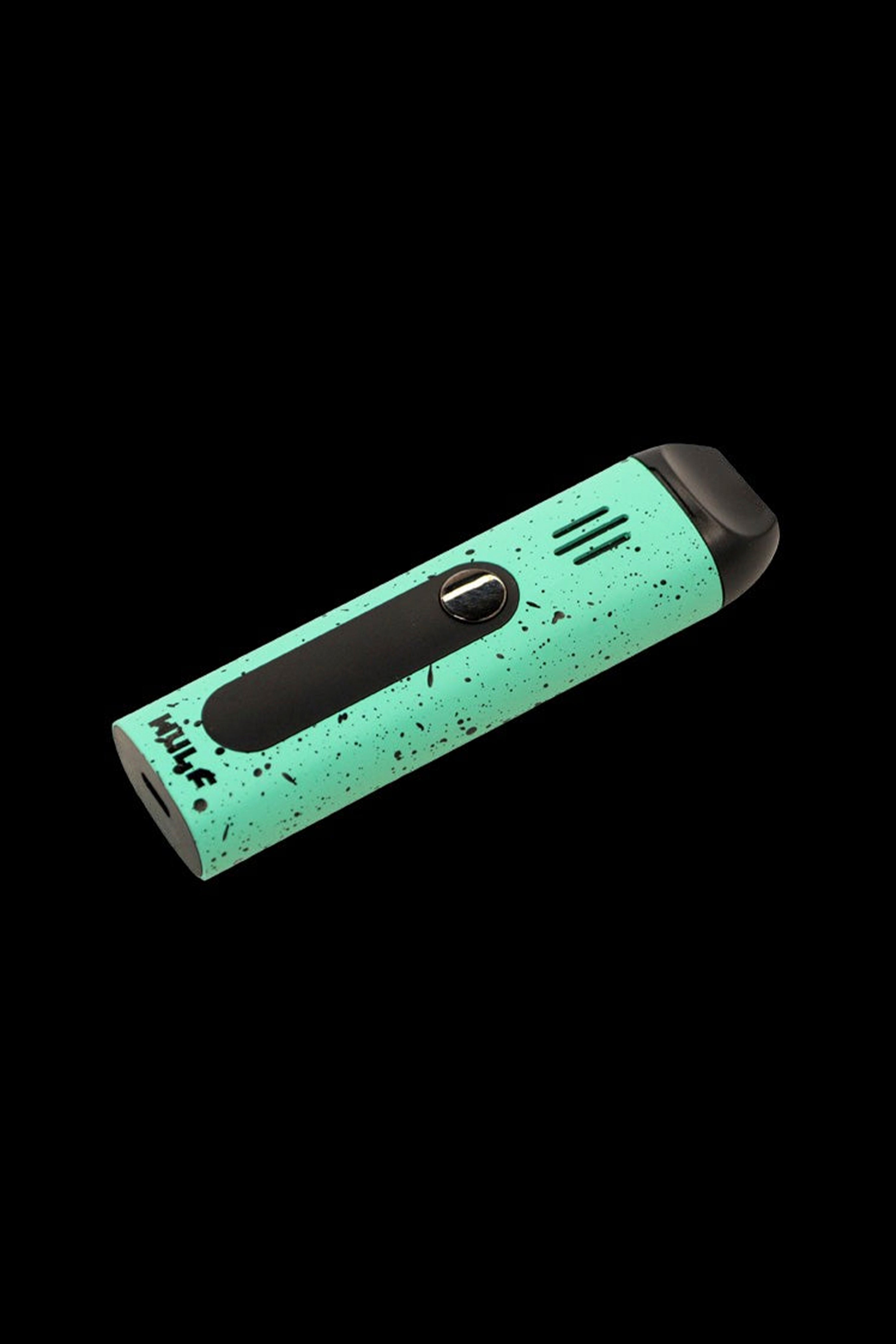 Green and black cannabis vape pen isolated on a black background.