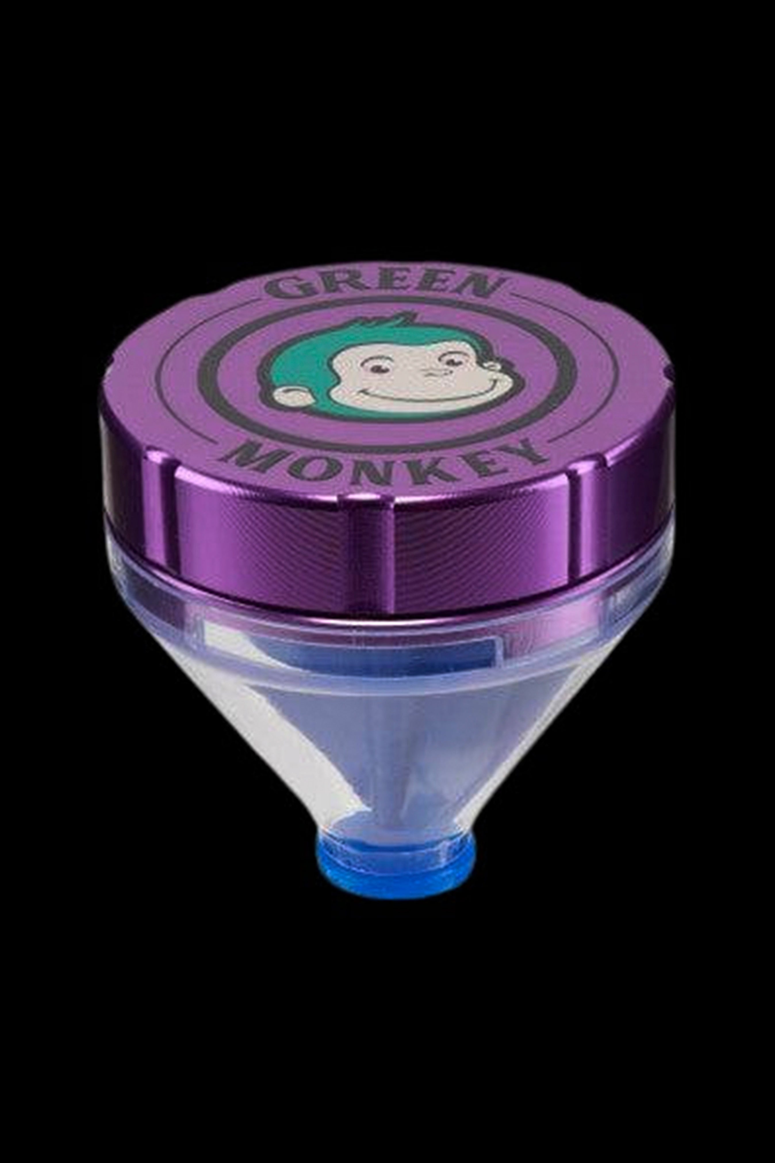 Top-down close-up of the Rainbow Green Monkey Patas Grinder showing its purple metallic lid with a smiling monkey logo and clear conical base