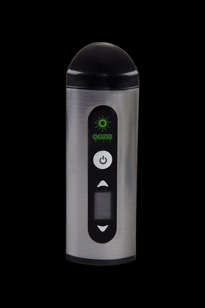 Silver cannabis vaporizer with digital display and controls against a black background.