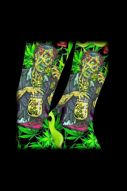 Two patterned cannabis accessory pouches with a vibrant, artistic design featuring a skeleton and foliage, displayed against a black background.