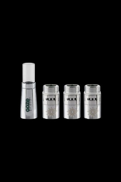 Silver cannabis oil cartridges and a clear glass tip, isolated on a black background.