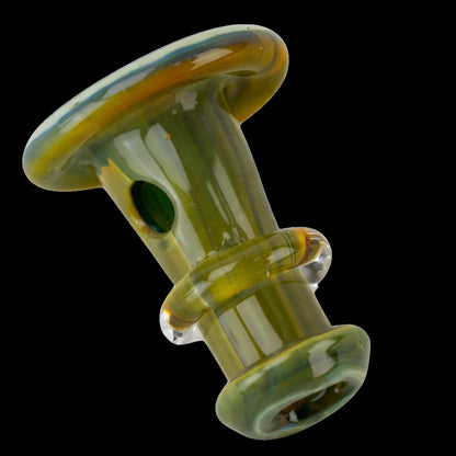 Angled close-up of the Empire Glassworks PuffCo 'New Peak' & Proxy Glass Joystick Cap showing its glossy green-yellow glass finish, rounded top rim and side hole against a black background