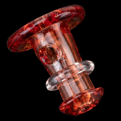 Close-up angled view of the Empire Glassworks PuffCo 'New Peak' & Proxy Glass Joystick Cap - Translucent Red showing glossy swirled red glass.