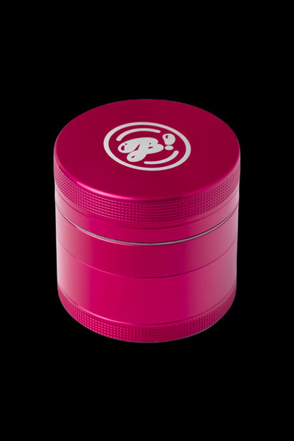 Pink four-piece metal grinder with a white logo.