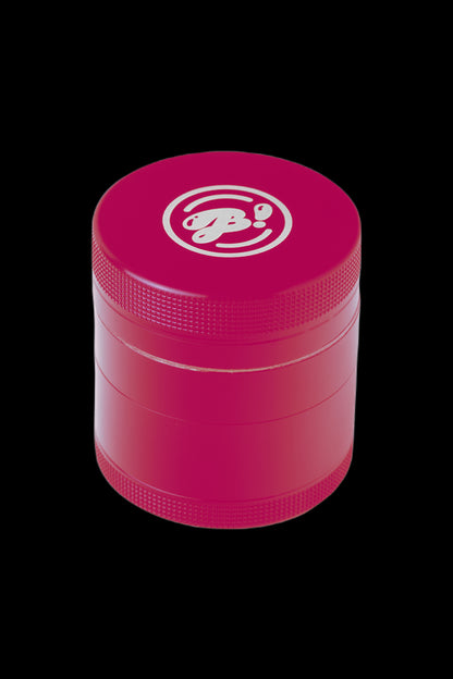 Pink four-piece cannabis grinder with a branded logo.