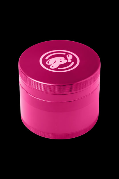 Pink four-piece cannabis grinder with a white logo.