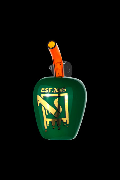 Green glass water pipe with gold lettering "EST. 2015" and dripping gold glaze, isolated on a black background.