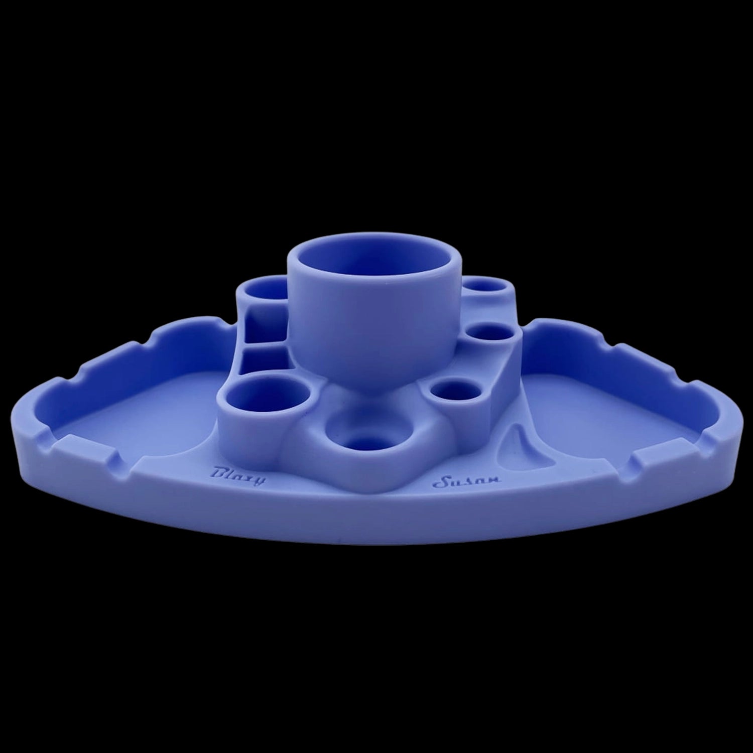 Low-angle view of the red Blazy Susan Deluxe Dab Station against a black background, showing its central cup and surrounding silicone wells.