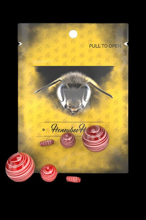 Packaging for “Honeybee” cannabis concentrates featuring a bee illustration and red hash pellets.